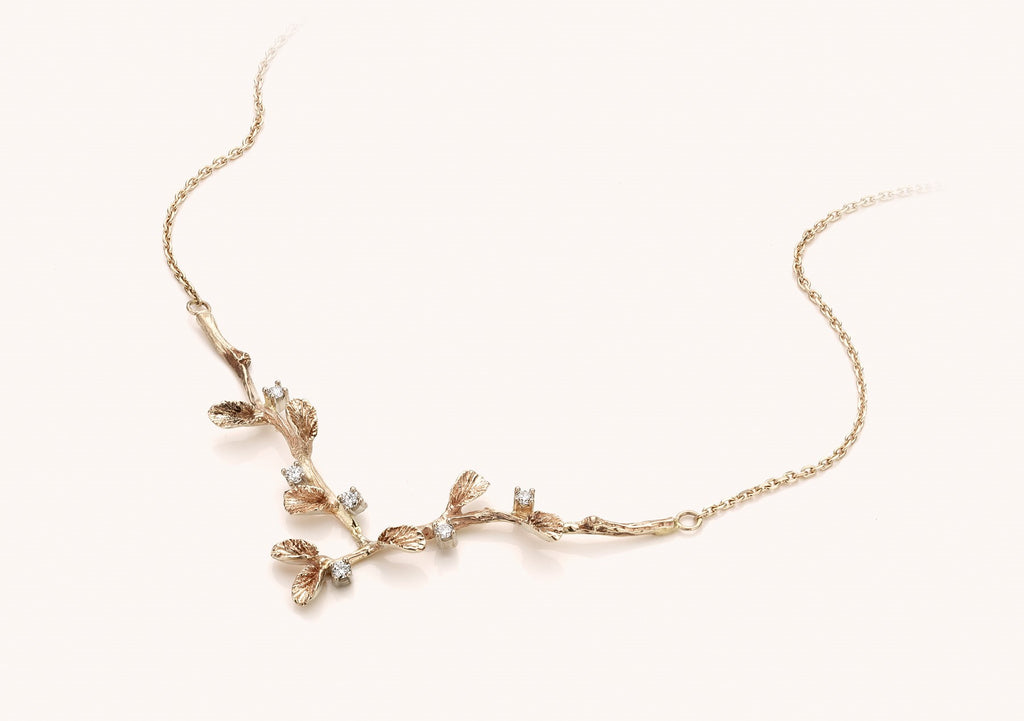 witgouden halsketting met diamant en takjes/blaadjes motief