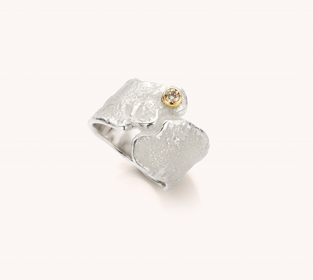 brede zilveren ring met bruine diamant in een geelgouden zetting
